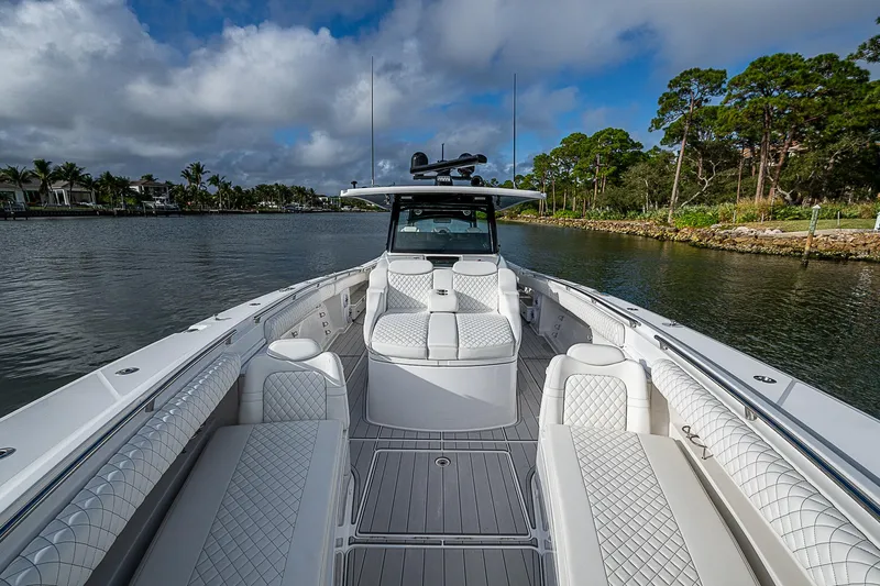  Yacht Photos Pics 2023 HCB 53 Sueños boat on a scenic waterway with lush greenery.