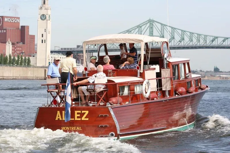 Allez Yacht Photos Pics 1930 Chris-Craft Commuter boat cruising near Montreal with passengers, cityscape in background.