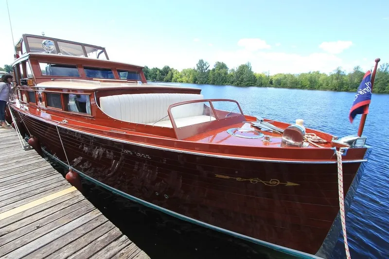 Allez Yacht Photos Pics 1930 Chris-Craft Commuter boat docked on a serene lake with clear skies.
