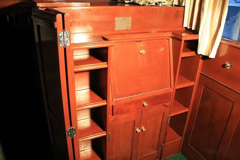 Allez Yacht Photos Pics Interior wooden cabinetry of a 1930 Chris-Craft Commuter boat, featuring shelves and storage compartments.