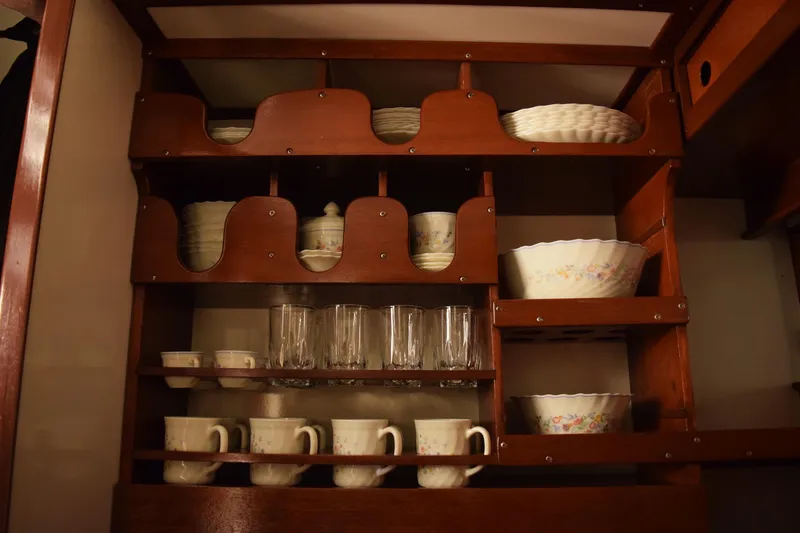 Allez Yacht Photos Pics Wooden cabinet with vintage dishes and glassware, inside a 1930 Chris-Craft Commuter boat.