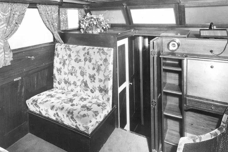 Allez Yacht Photos Pics Interior of a 1930 Chris-Craft Commuter boat with floral upholstery and wooden cabinetry.