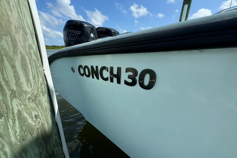  Yacht Photos Pics 2018 Conch 30 boat docked, featuring dual outboard engines under a clear sky.