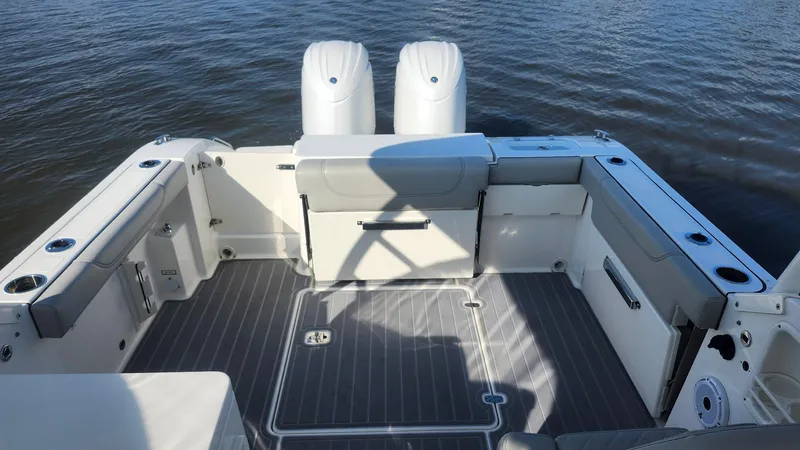  Yacht Photos Pics 2024 Pursuit DC 266 Dual Console boat interior with seating and twin engines on water.