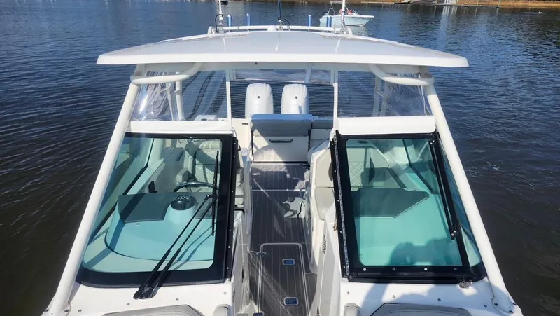  Yacht Photos Pics 2024 Pursuit DC 266 Dual Console boat on calm water, showcasing sleek design and spacious interior.