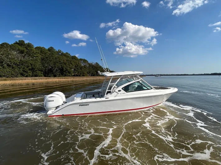  Yacht Photos Pics 2024 Pursuit DC 266 Dual Console boat cruising on a sunny day with clear skies.