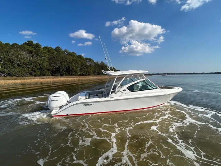  Yacht Photos Pics 2024 Pursuit DC 266 Dual Console boat cruising on a sunny day with clear skies.
