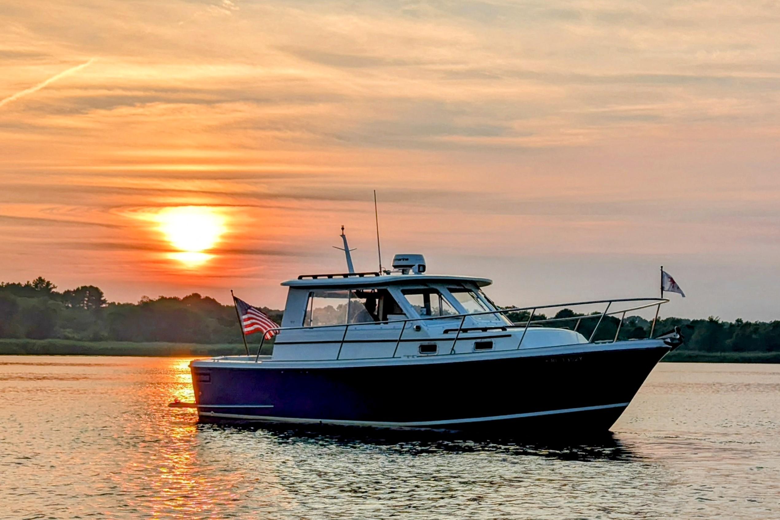 Hunt Yachts 28 Express 2000 cruising at sunset on calm waters.