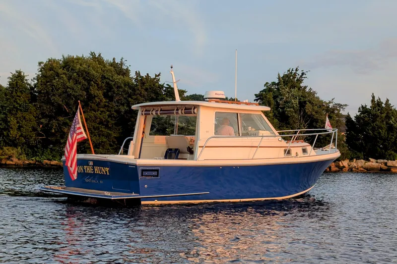 Yacht Photos Pics 2000 Hunt Yachts 28 Express boat on water, American flag, trees in background.