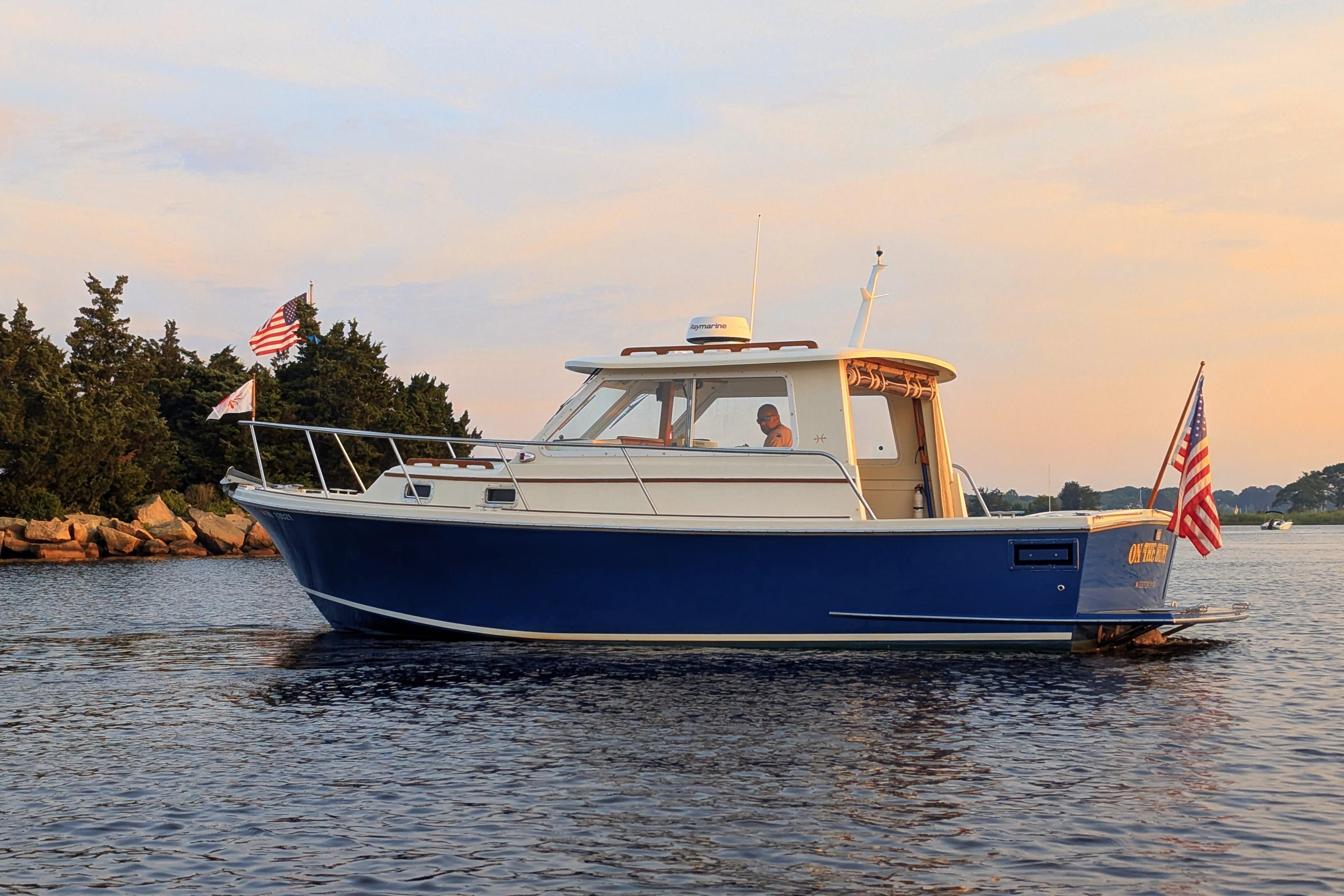 2000 Hunt Yachts 28 Express cruising on calm waters at sunset.