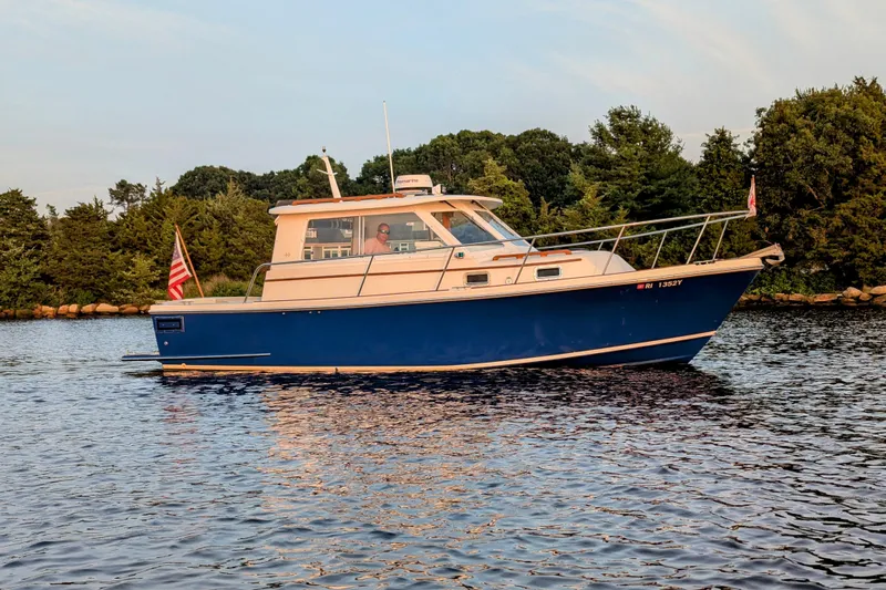  Yacht Photos Pics 2000 Hunt Yachts 28 Express cruising on calm water, surrounded by lush greenery.