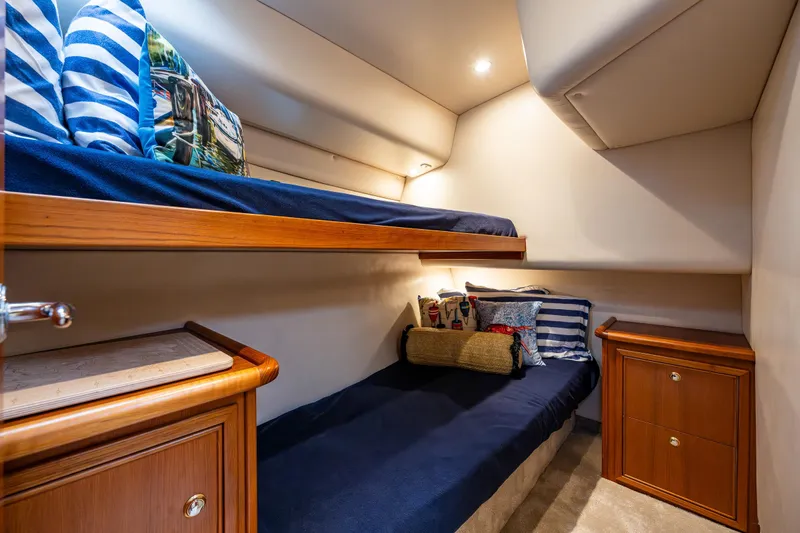 Yacht Photos Pics Cozy cabin interior of 2004 Riviera 37 Flybridge with bunk beds and nautical decor.