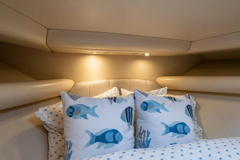  Yacht Photos Pics Luxurious 2004 Riviera 37 Flybridge cabin with fish-themed pillows and cozy lighting.
