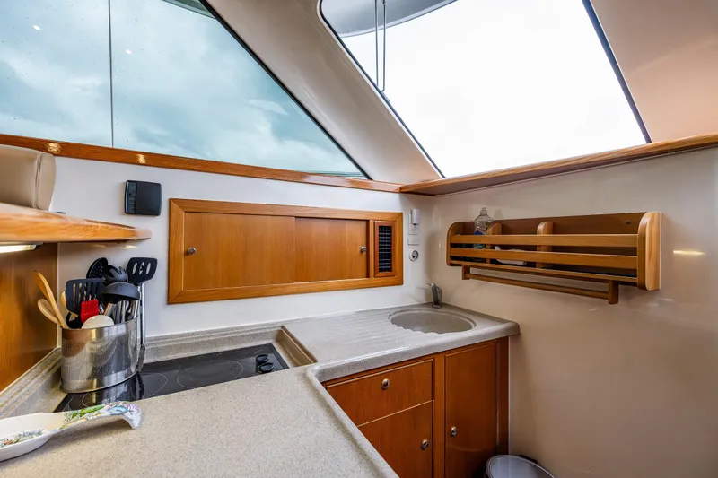  Yacht Photos Pics 2004 Riviera 37 Flybridge yacht kitchen with modern amenities and wooden cabinetry.