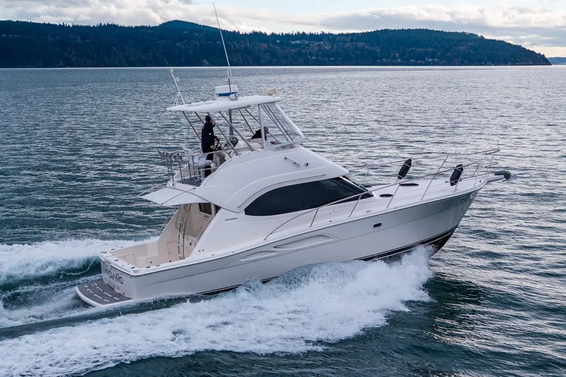  Yacht Photos Pics 2004 Riviera 37 Flybridge yacht cruising on open water with scenic island backdrop.