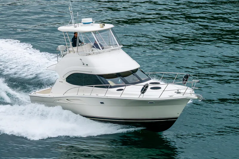  Yacht Photos Pics 2004 Riviera 37 Flybridge yacht cruising on open water.