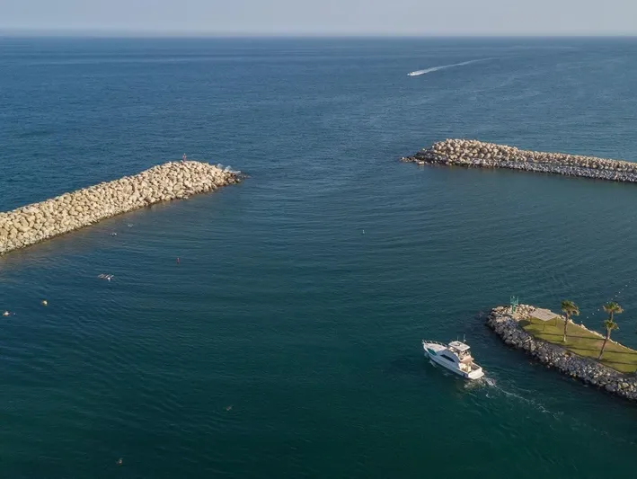  Yacht Photos Pics Aerial view of 2005 Riviera 47 Convertible Series II yacht exiting marina into open sea.