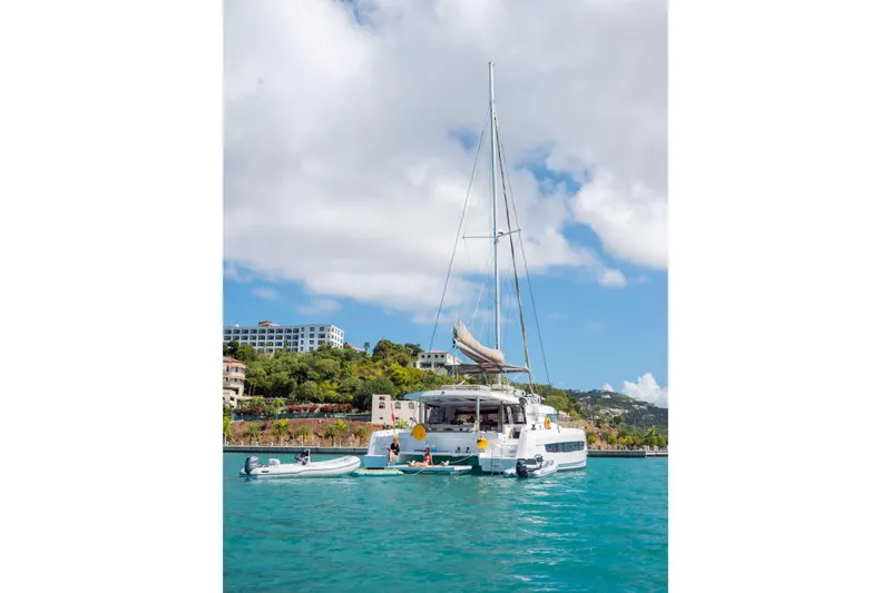 Southern Queen Yacht Photos Pics 2022 Bali 5.4 catamaran anchored in turquoise waters, with scenic coastal backdrop.