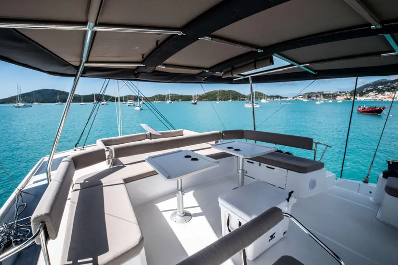 Southern Queen Yacht Photos Pics Luxurious 2022 Bali 5.4 catamaran with spacious deck, overlooking serene turquoise waters and anchored boats.