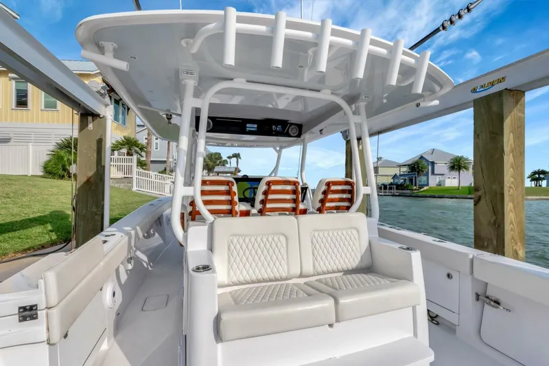 Aqua Toy Yacht Photos Pics 2023 Jupiter 43 Center Console boat interior with seating, docked by waterfront homes.
