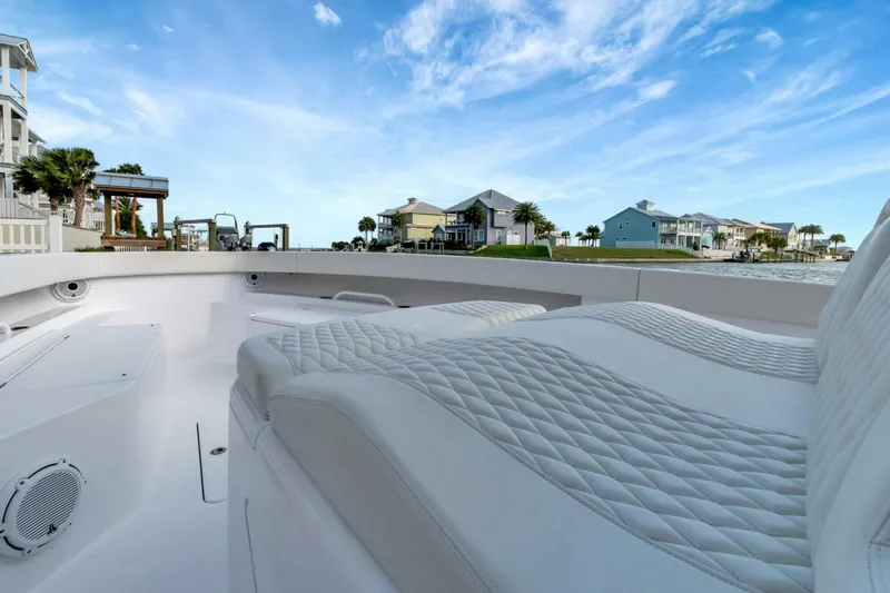 Aqua Toy Yacht Photos Pics Luxurious seating on 2023 Jupiter 43 Center Console boat, with coastal homes in background.