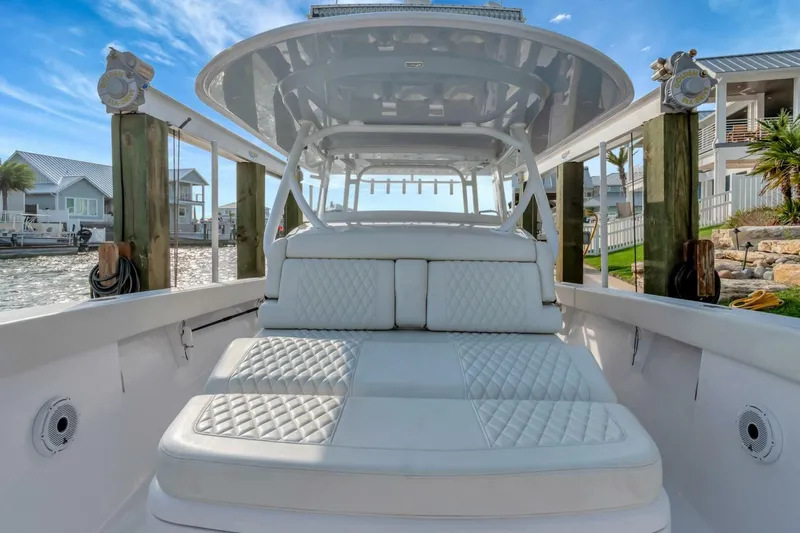 Aqua Toy Yacht Photos Pics 2023 Jupiter 43 Center Console boat with luxurious seating, docked by waterfront homes.