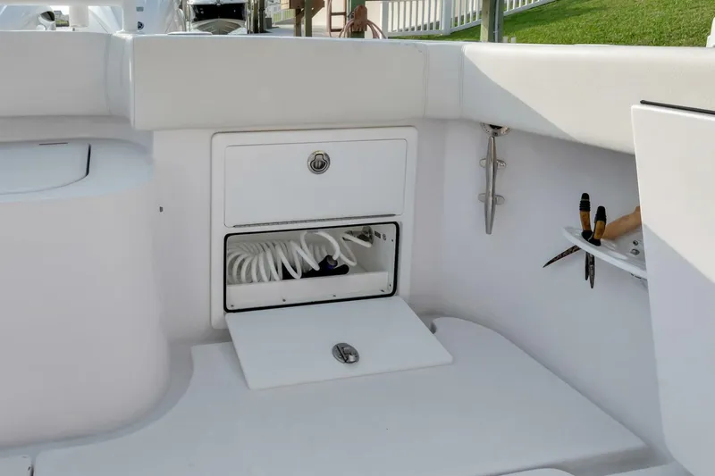 Aqua Toy Yacht Photos Pics 2023 Jupiter 43 Center Console boat storage compartment with coiled hose and tools.