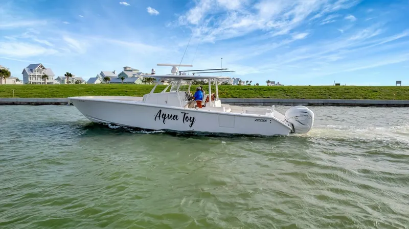 Aqua Toy Yacht Photos Pics 2023 Jupiter 43 Center Console boat cruising on a sunny day with clear skies.