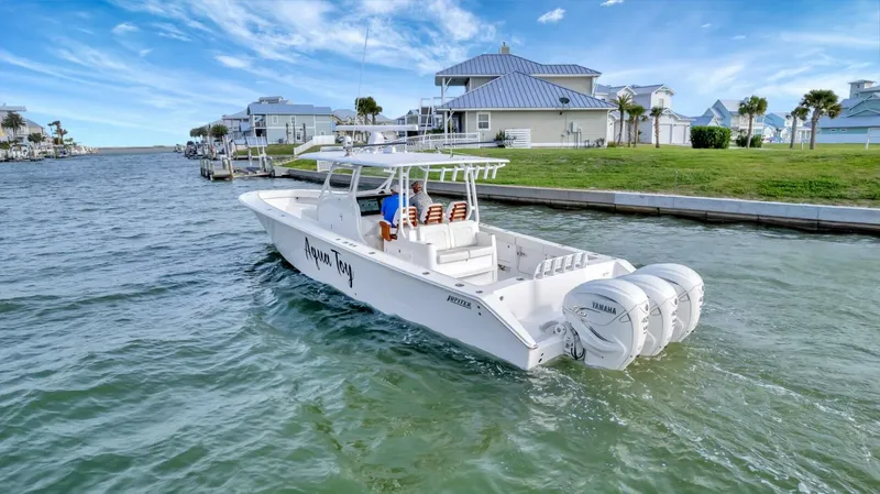 Aqua Toy Yacht Photos Pics 2023 Jupiter 43 Center Console boat cruising near waterfront homes.