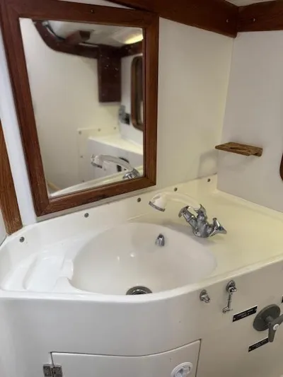  Yacht Photos Pics Bathroom sink area in a 1996 J Boats J/120 yacht, featuring a mirror and faucet.