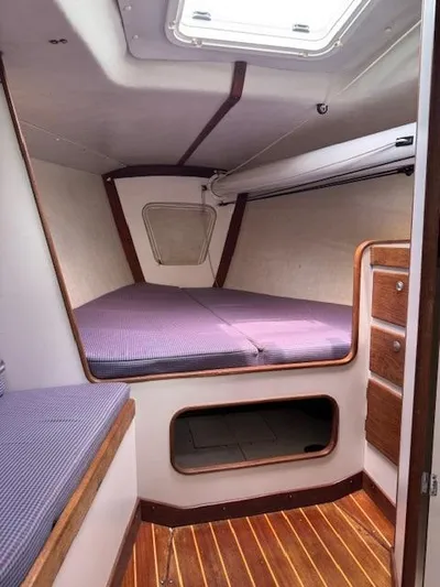  Yacht Photos Pics 1996 J Boats J/120 cabin interior with purple cushions and wooden accents.