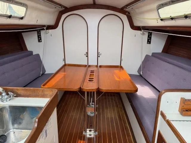  Yacht Photos Pics Interior of a 1996 J Boats J/120 sailboat with wooden table and seating.