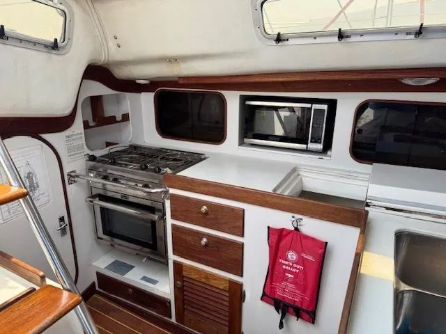 Yacht Photos Pics Interior of 1996 J Boats J/120, featuring a compact kitchen with stove, oven, and microwave.