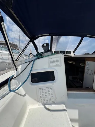  Yacht Photos Pics 1996 J Boats J/120 cockpit with winch, ropes, and navigation instruments under a blue canopy.