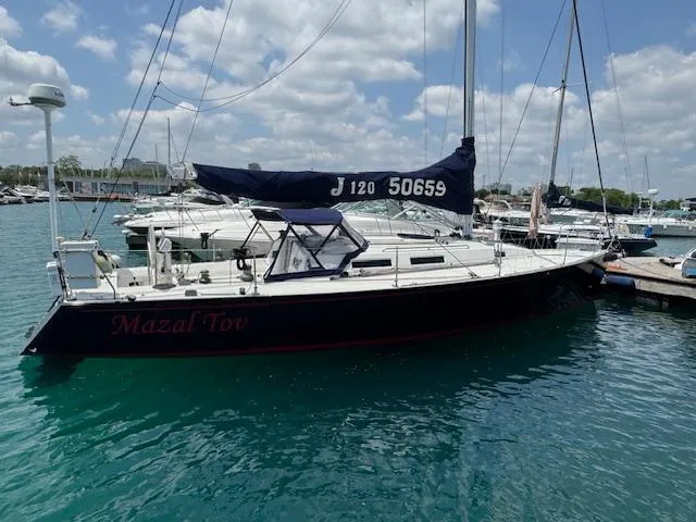  Yacht Photos Pics Sailboat J/120 from 1996 docked in a marina under a clear sky.