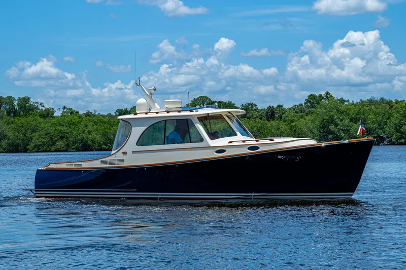 Norora Yacht Photos Pics 2016 Hinckley Picnic Boat 37 MKIII cruising on a sunny day with lush greenery in the background.