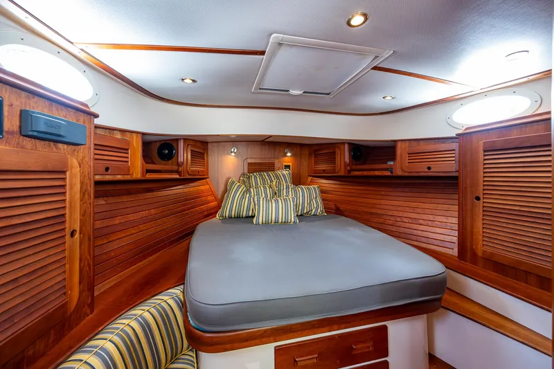 Norora Yacht Photos Pics Luxurious cabin interior of 2016 Hinckley Picnic Boat 37 MKIII with wood finish and cozy bedding.