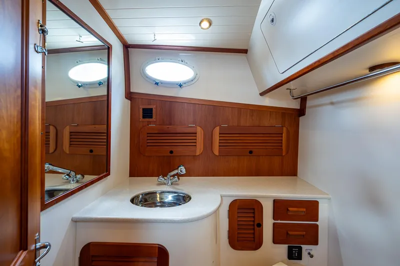 Norora Yacht Photos Pics 2016 Hinckley Picnic Boat 37 MKIII bathroom with wooden cabinetry and stainless steel sink.