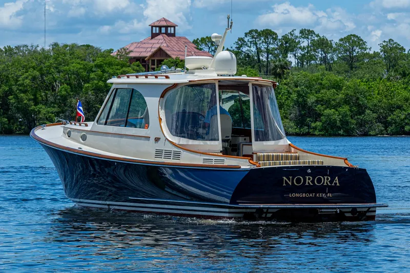 Norora Yacht Photos Pics 2016 Hinckley Picnic Boat 37 MKIII cruising on a serene lake with lush greenery.