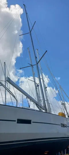 Pelican Yacht Photos Pics Dufour 460 Grand Large 2020 sailboat with tall masts against a blue sky and clouds.