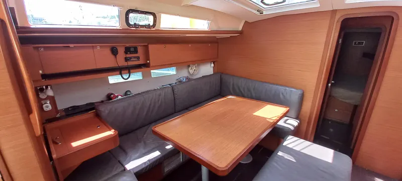 Pelican Yacht Photos Pics 2020 Dufour 460 Grand Large yacht interior with dining area and wooden furnishings.