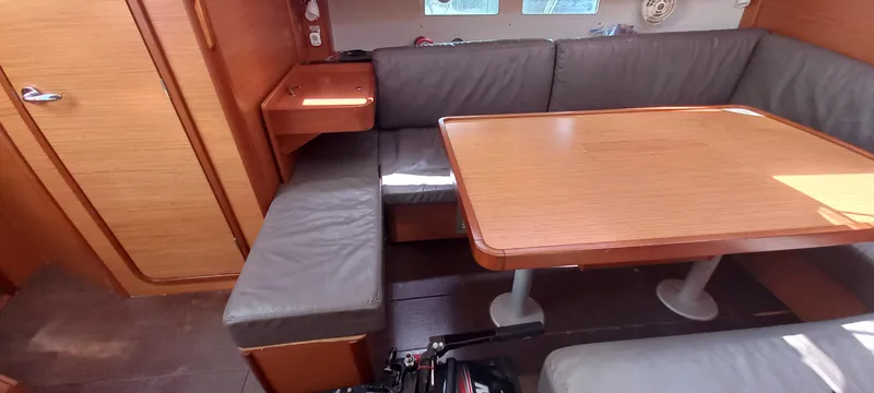 Pelican Yacht Photos Pics 2020 Dufour 460 Grand Large yacht interior with wooden table and cushioned seating.