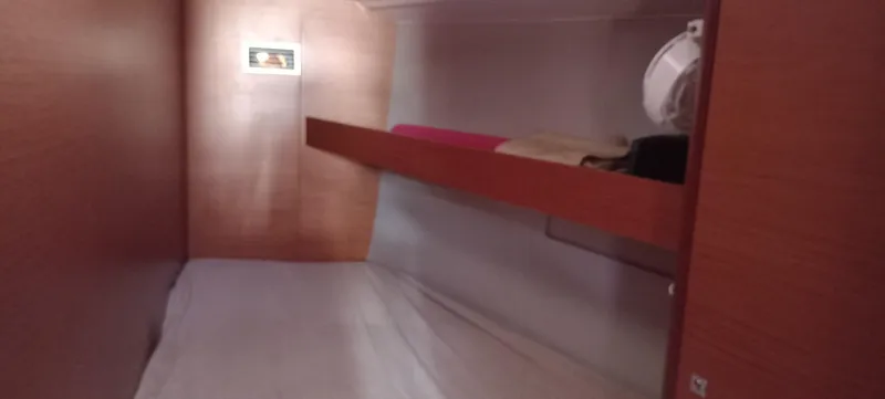 Pelican Yacht Photos Pics Interior cabin of 2020 Dufour 460 Grand Large yacht, featuring wooden finish and bedding.