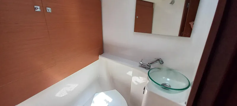 Pelican Yacht Photos Pics Modern bathroom in 2020 Dufour 460 Grand Large yacht with glass sink and wooden accents.