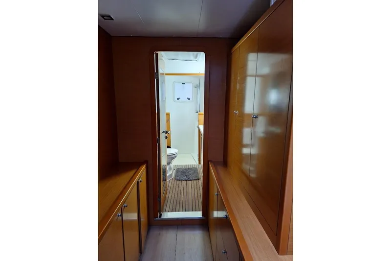 Kala Yacht Photos Pics Interior view of 2016 Lagoon 450 F yacht, featuring wooden cabinetry and bathroom access.