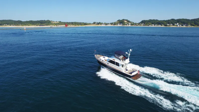 Phoenix Yacht Photos Pics 2014 Grand Banks 46 Eastbay FB cruising on open water near a scenic coastline.