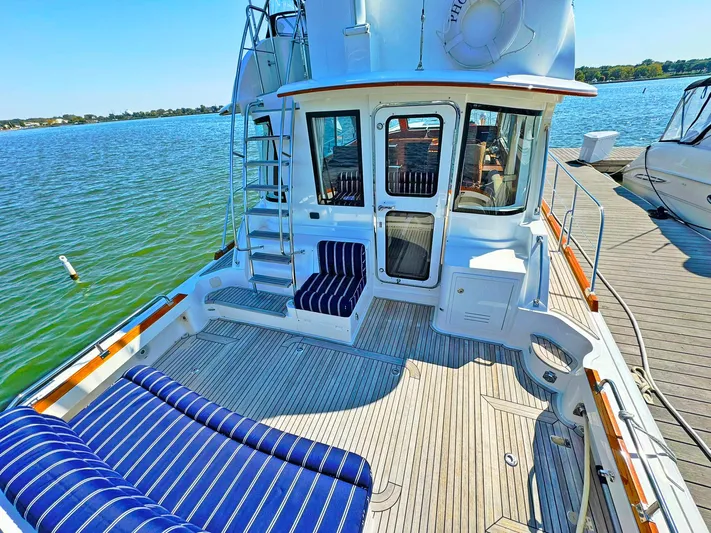 Phoenix Yacht Photos Pics 2014 Grand Banks 46 Eastbay FB yacht with spacious deck and striped seating by the water.