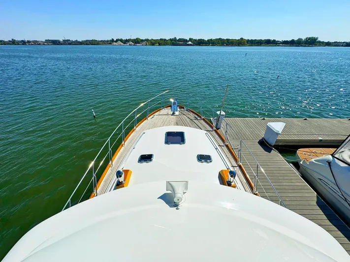 Phoenix Yacht Photos Pics 2014 Grand Banks 46 Eastbay FB yacht docked on calm water, sunny day.