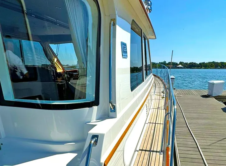Phoenix Yacht Photos Pics 2014 Grand Banks 46 Eastbay FB yacht docked by a serene waterfront.