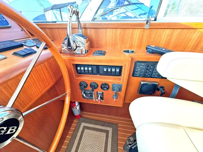 Phoenix Yacht Photos Pics Helm of 2014 Grand Banks 46 Eastbay FB with wooden finish and control panel.